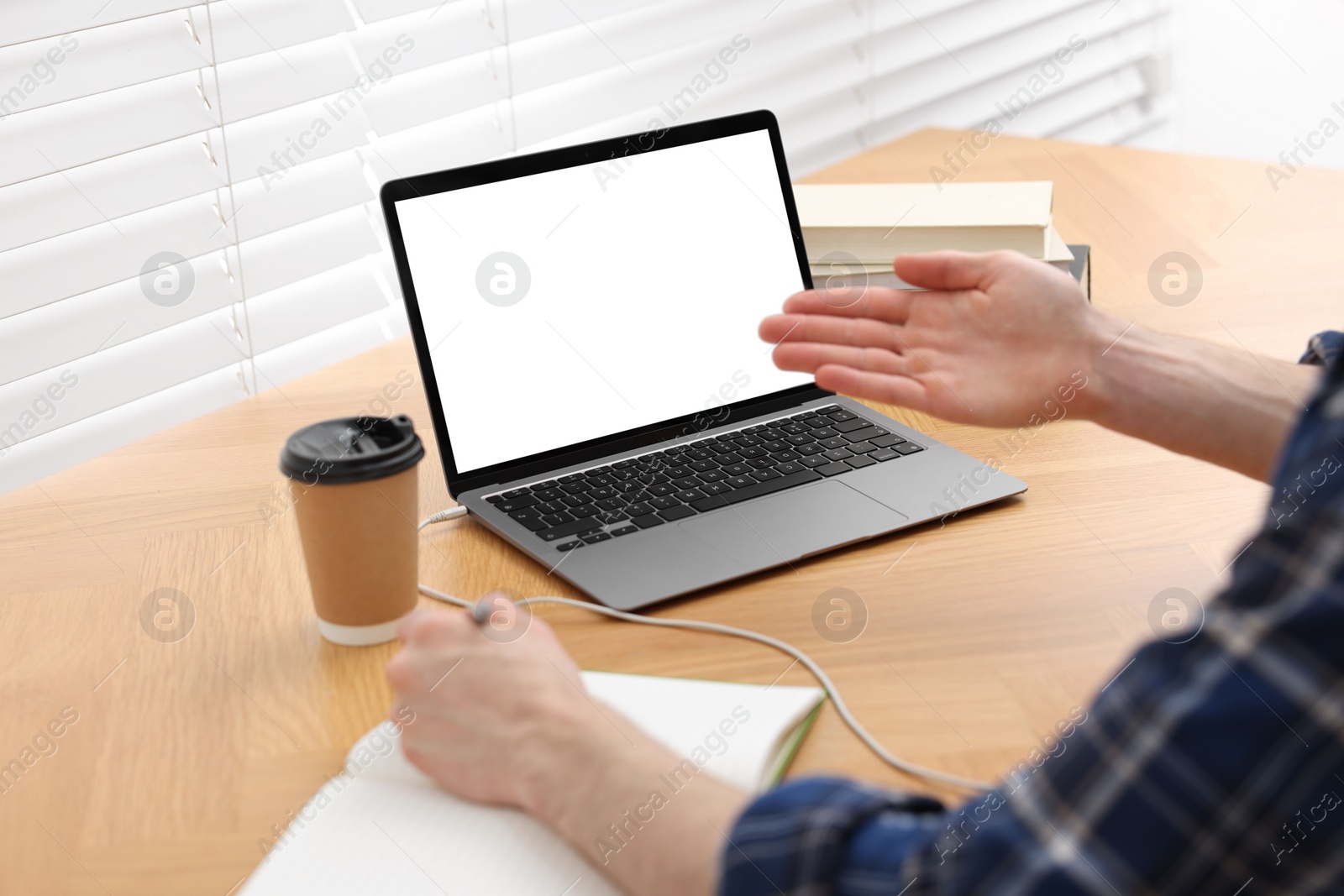 Photo of E-learning. Man using laptop during online lesson at table indoors, closeup