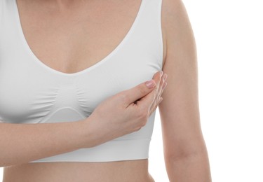 Photo of Mammology. Young woman doing breast self-examination on white background, closeup