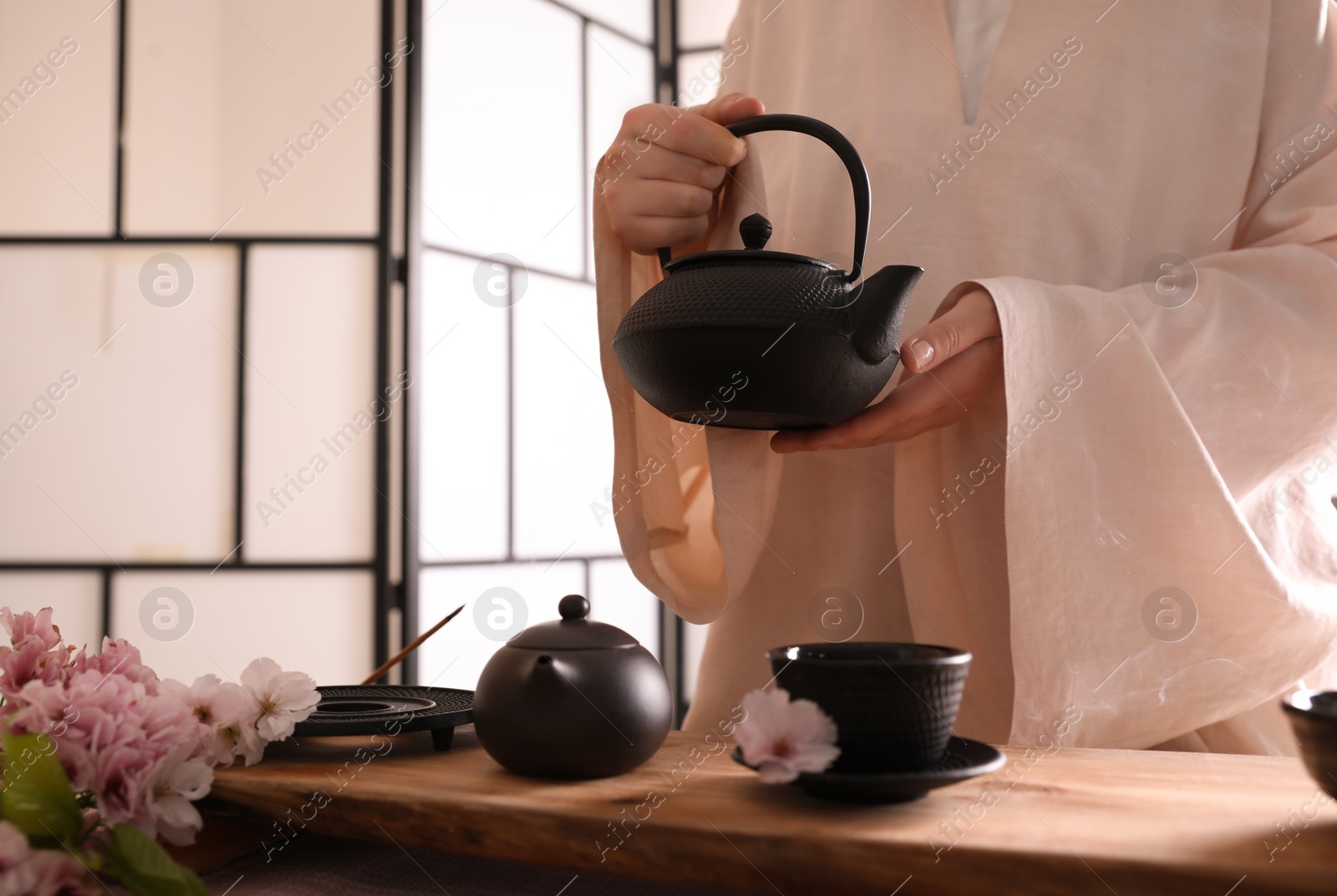 Photo of Master conducting traditional tea ceremony at table, closeup