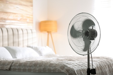 Photo of Modern electric fan in bedroom. Space for text