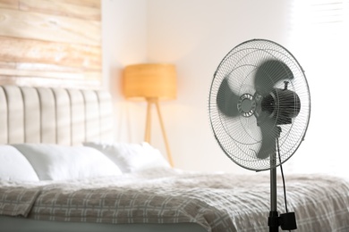 Modern electric fan in bedroom. Space for text