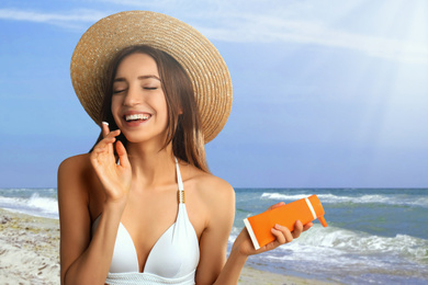 Image of Young woman applying sun protection cream at beach