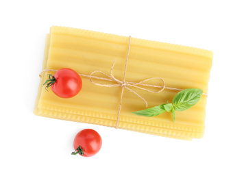 Photo of Uncooked lasagna sheets, cherry tomatoes and basil isolated on white, top view