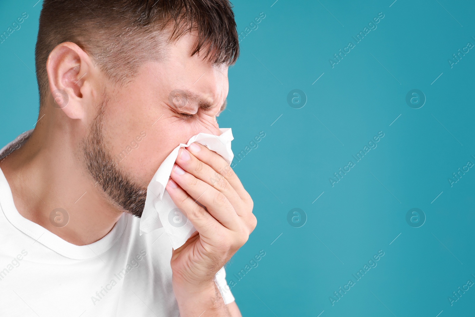 Photo of Man suffering from allergy on blue background. Space for text