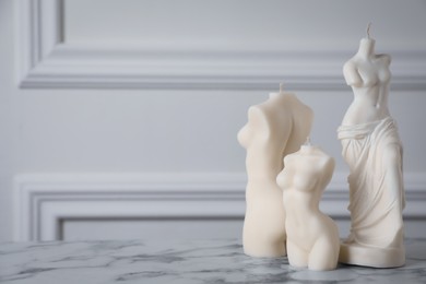 Photo of Beautiful sculptural candles on white marble table, space for text. Stylish decor