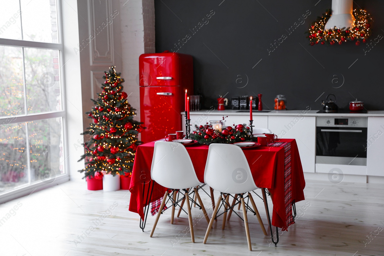 Photo of Stylish kitchen interior with festive table and decorated Christmas tree