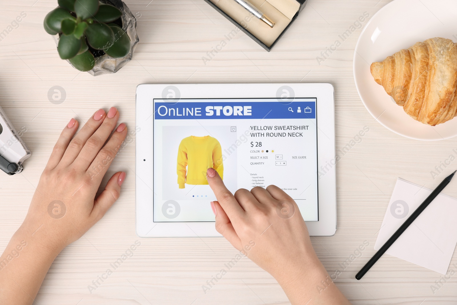 Photo of Woman with tablet shopping online at white wooden table, top view