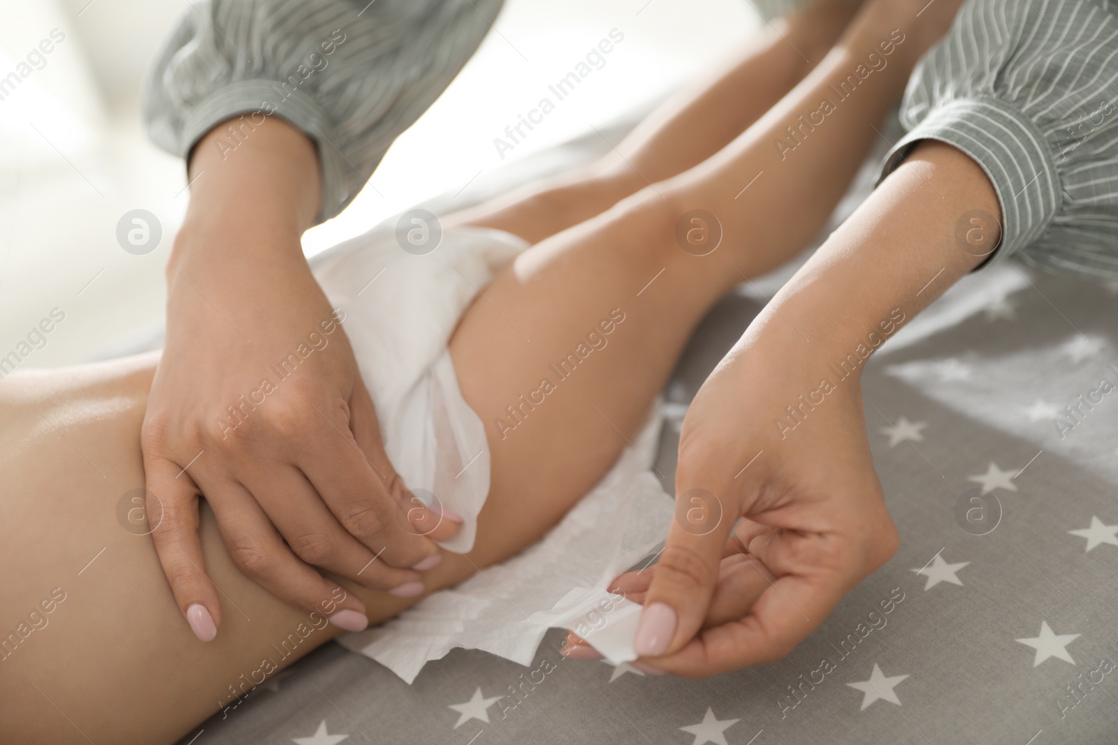 Photo of Mother changing baby's diaper on table at home, closeup