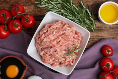 Raw chicken minced meat and ingredients on wooden table, flat lay