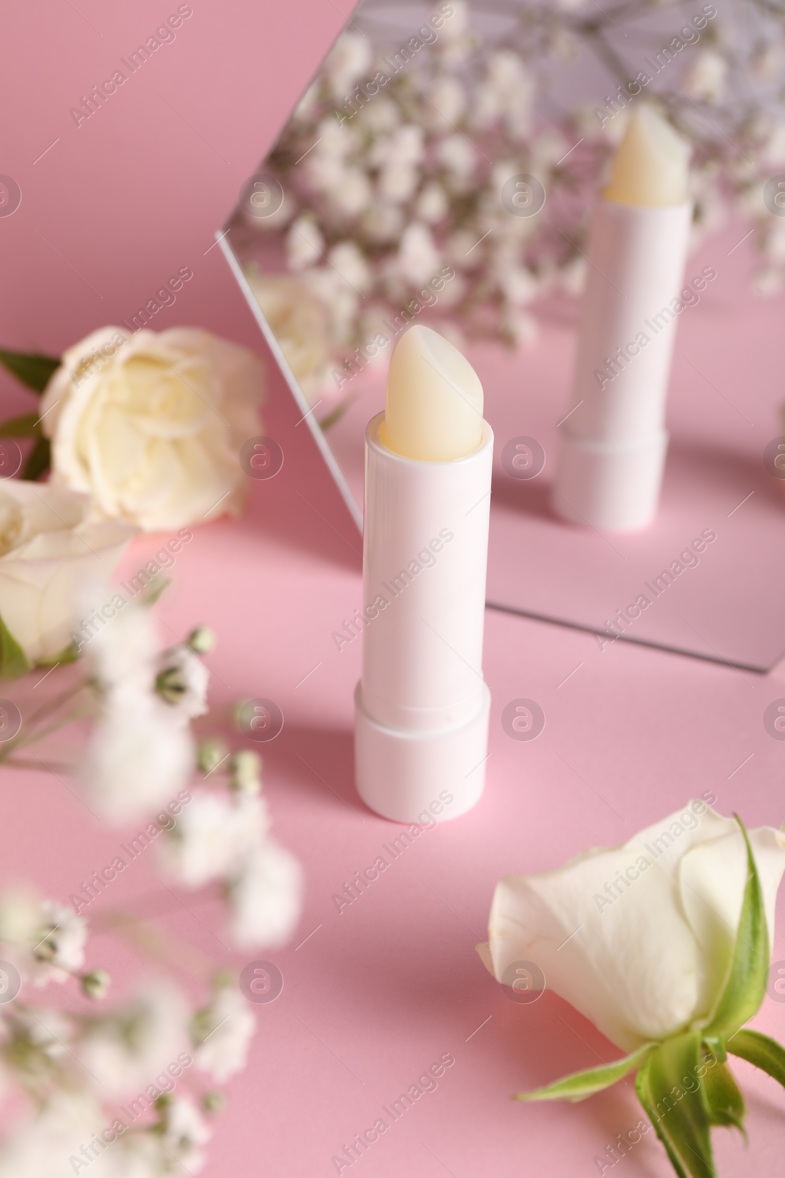 Photo of Stylish presentation of lip balm on pink background, closeup