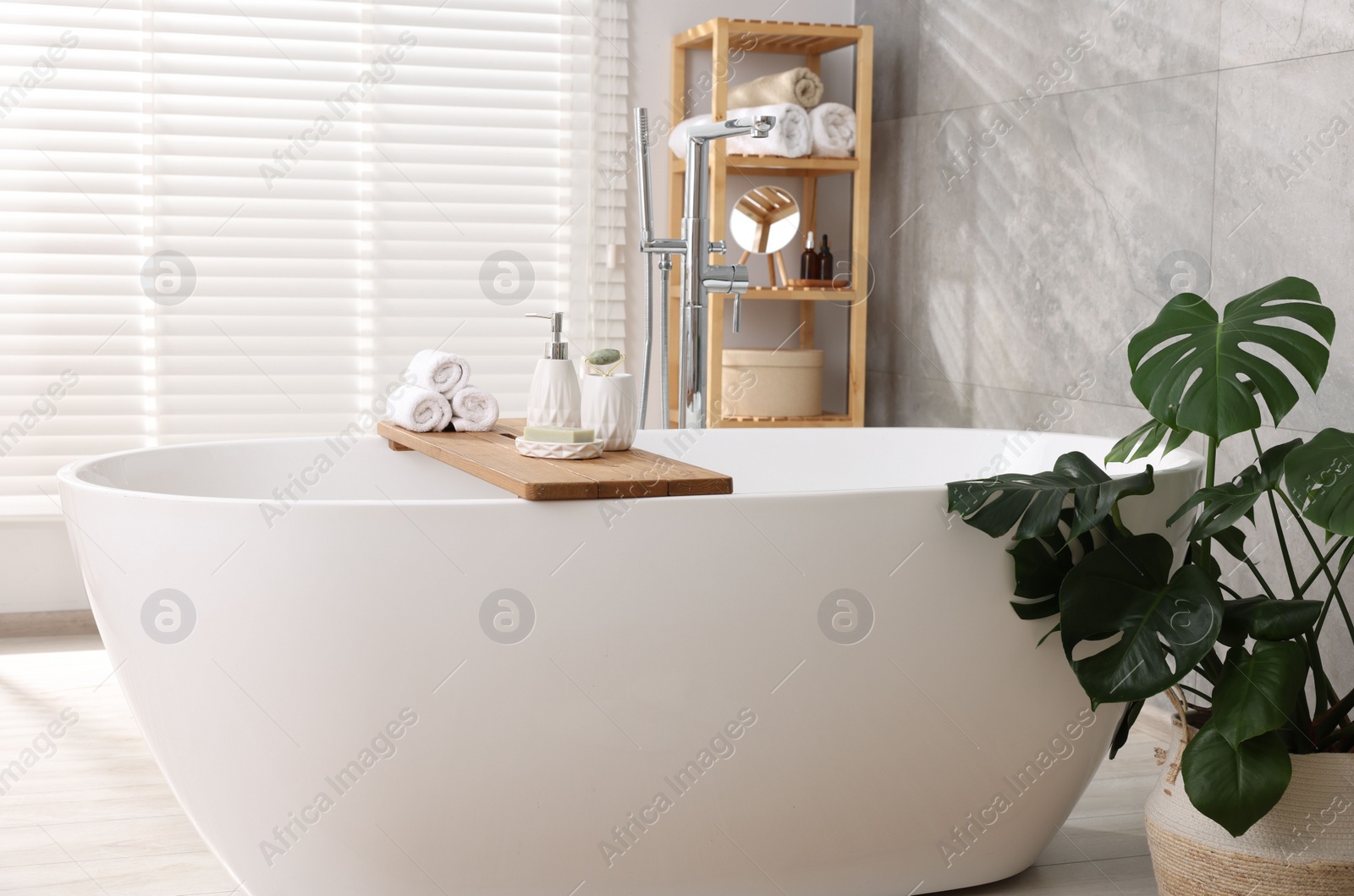 Photo of Different personal care products on bath tub in bathroom