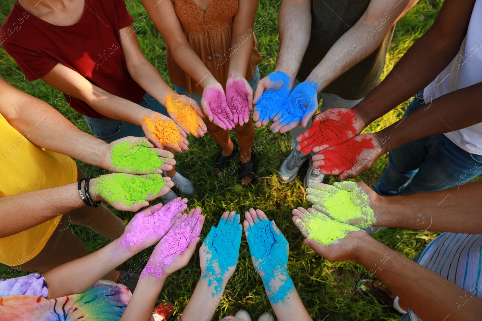 Photo of Friends with colorful powder dyes outdoors, closeup. Holi festival celebration