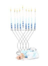 Photo of Hanukkah celebration. Menorah with candles, gift boxes and wooden dreidels isolated on white