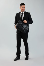 Photo of Businessman with stylish leather briefcase on light background