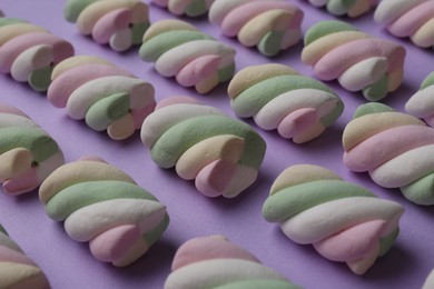 Delicious colorful marshmallows on violet background, closeup