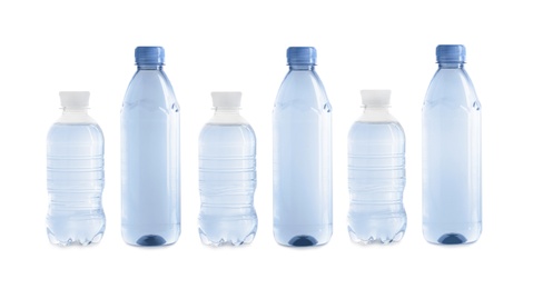 Row of different plastic bottles with water on white background