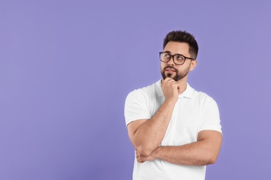 Photo of Handsome man wearing glasses on violet background, space for text
