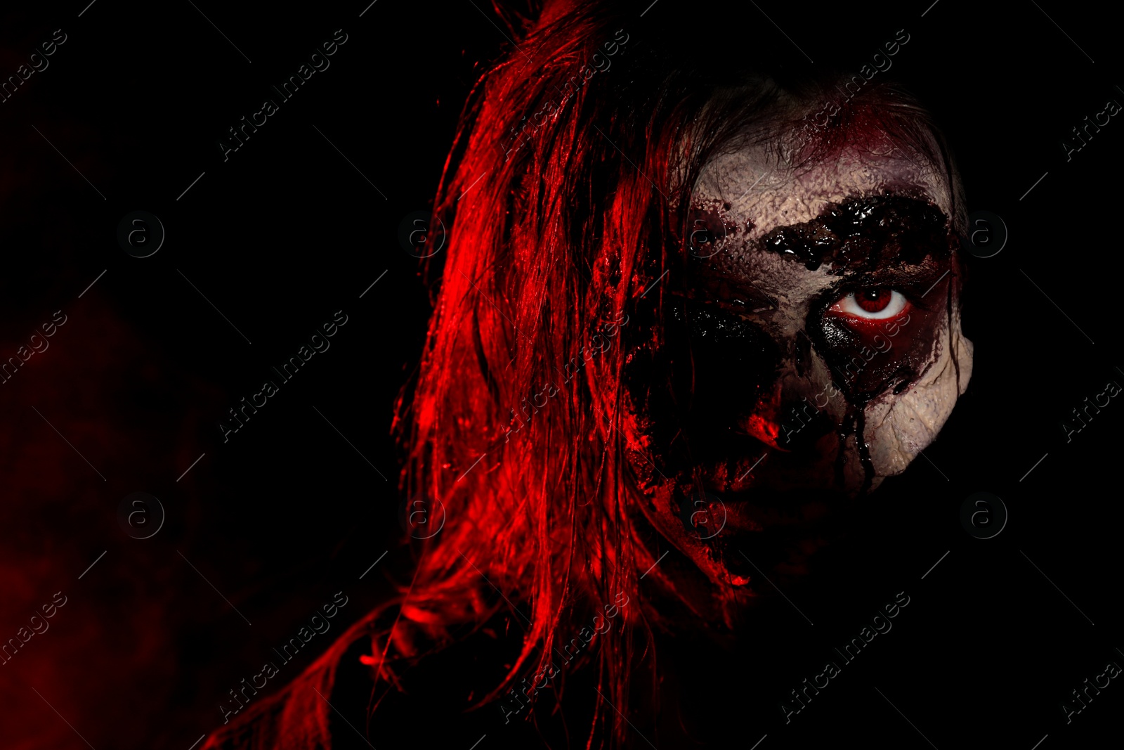 Photo of Scary zombie on dark background, closeup. Halloween monster