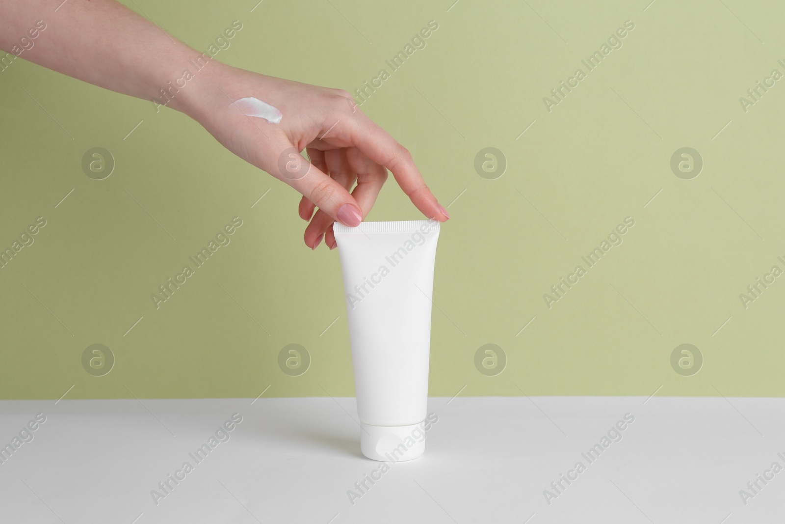 Photo of Woman with tube of cream on color background, closeup. Space for text