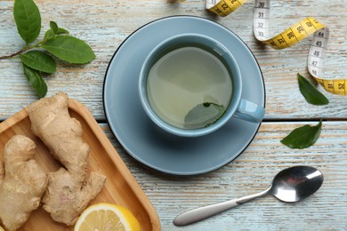 Photo of Flat lay composition with cup of diet herbal tea on light wooden background