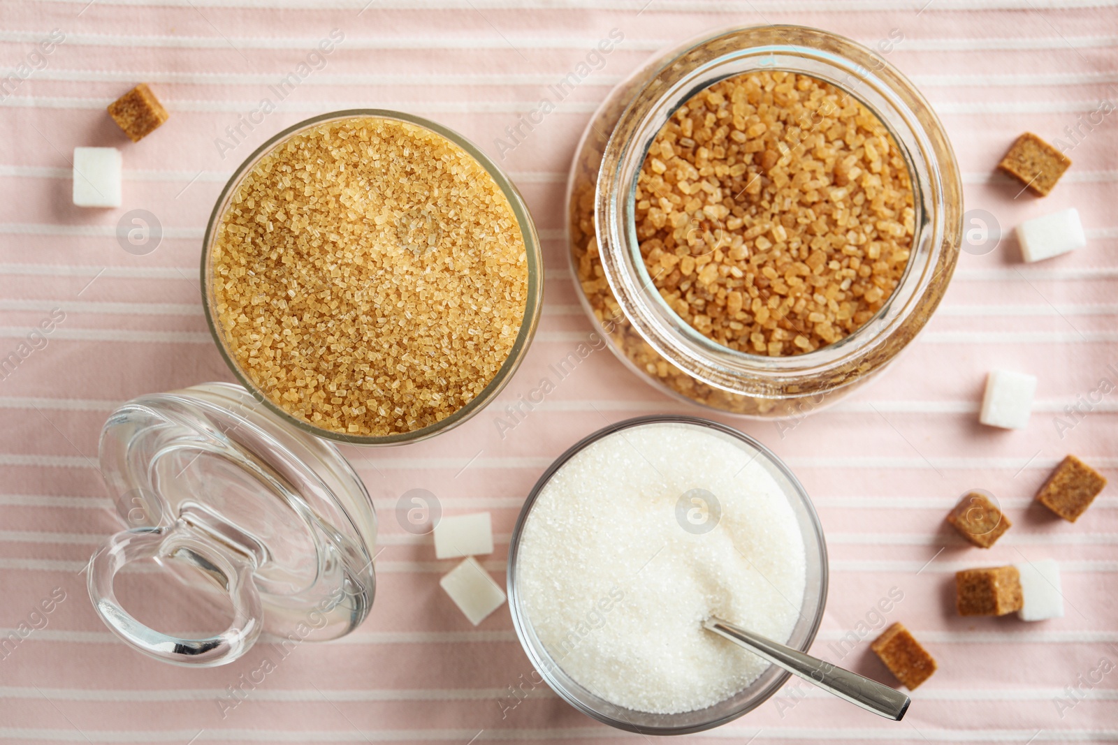 Photo of Various bowls with different sorts of sugar on table, flat lay