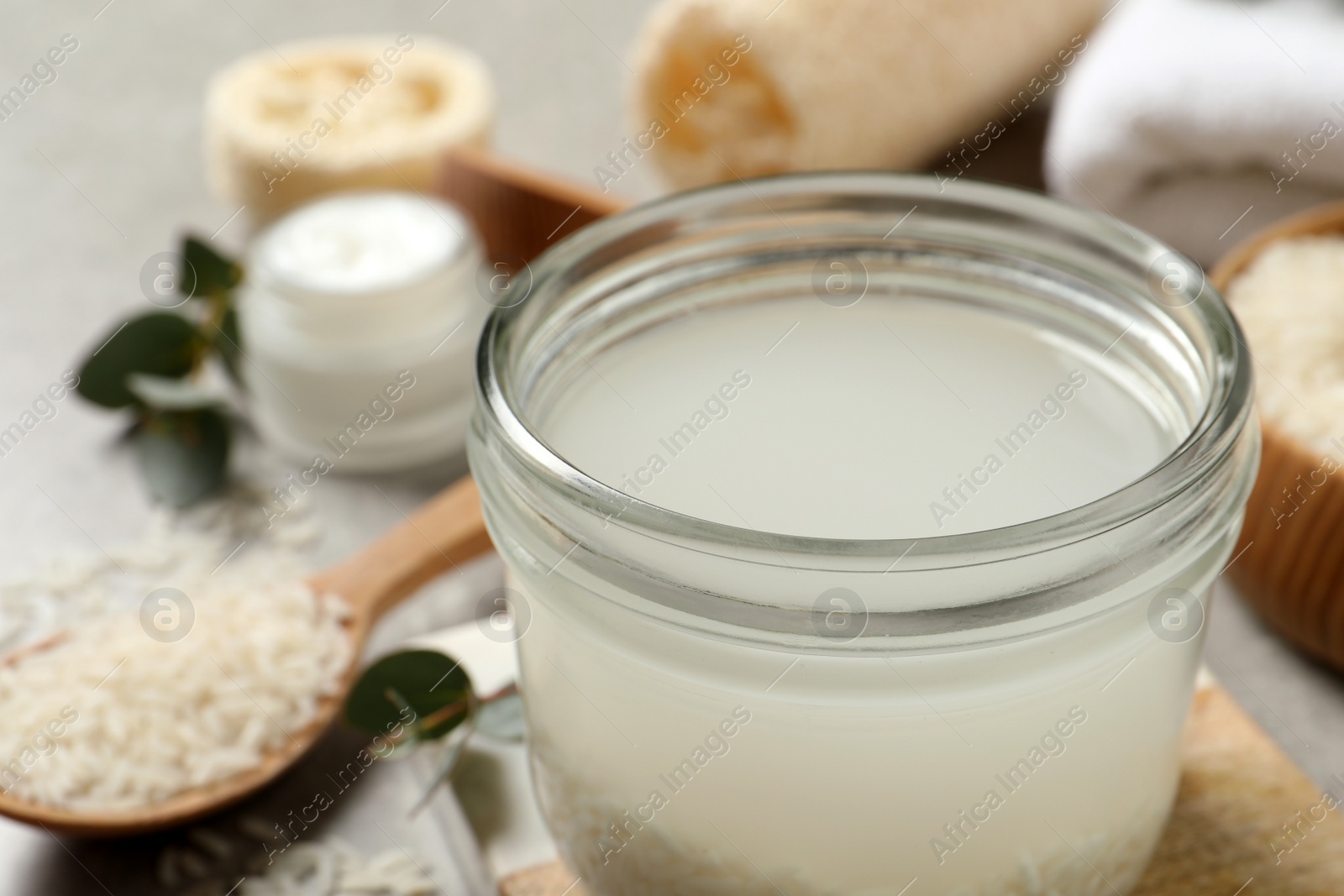 Photo of Glass jar with rice soaked in water on table, closeup