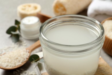 Photo of Glass jar with rice soaked in water on table, closeup