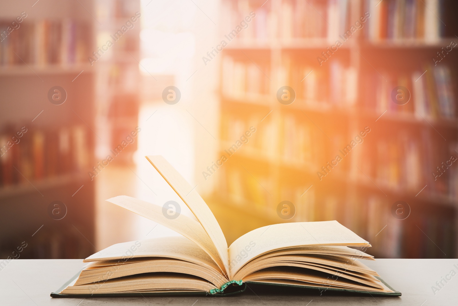 Image of Open hardcover book on table in library