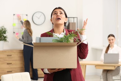 Unemployment problem. Woman with box of personal belongings in office