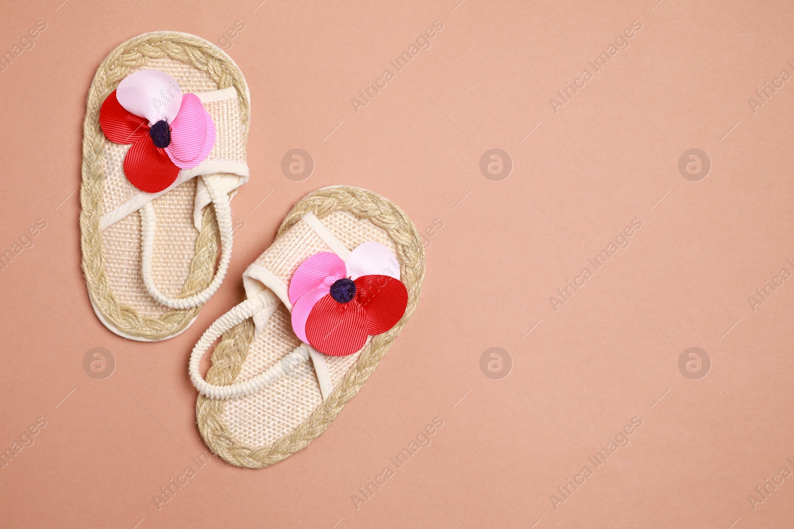 Photo of Cute baby shoes on brown background, flat lay. Space for text