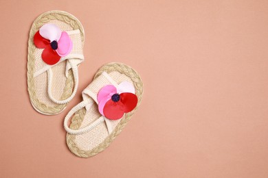 Cute baby shoes on brown background, flat lay. Space for text