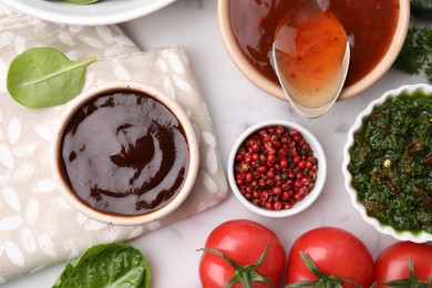 Photo of Different marinades and products on white marble table, flat lay