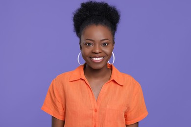 Photo of Portrait of happy young woman on purple background
