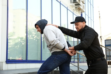 Police officer arresting dangerous criminal on street