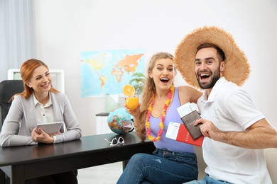 Beautiful young couple visiting travel agency office