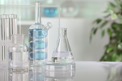 Laboratory analysis. Different glassware with liquid on white table indoors. Space for text