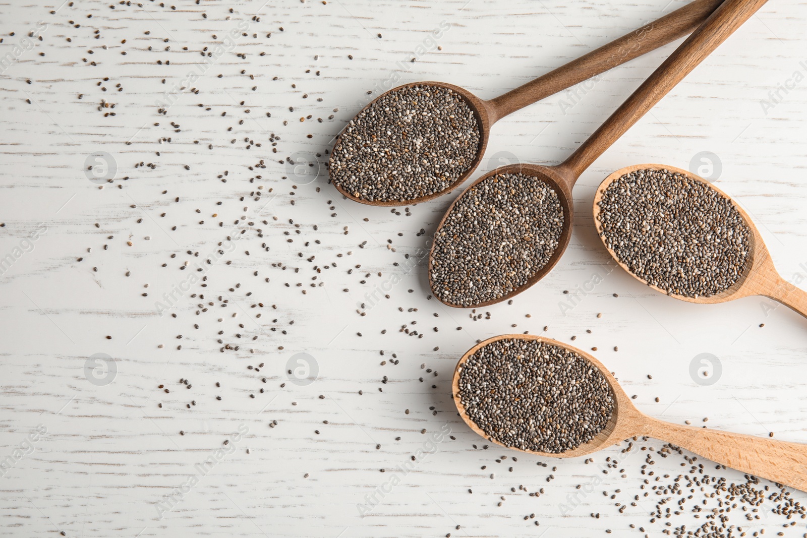 Photo of Spoons with chia seeds on wooden background, flat lay. Space for text