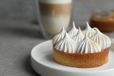 Tartlet with meringue on grey table, closeup and space for text. Delicious dessert