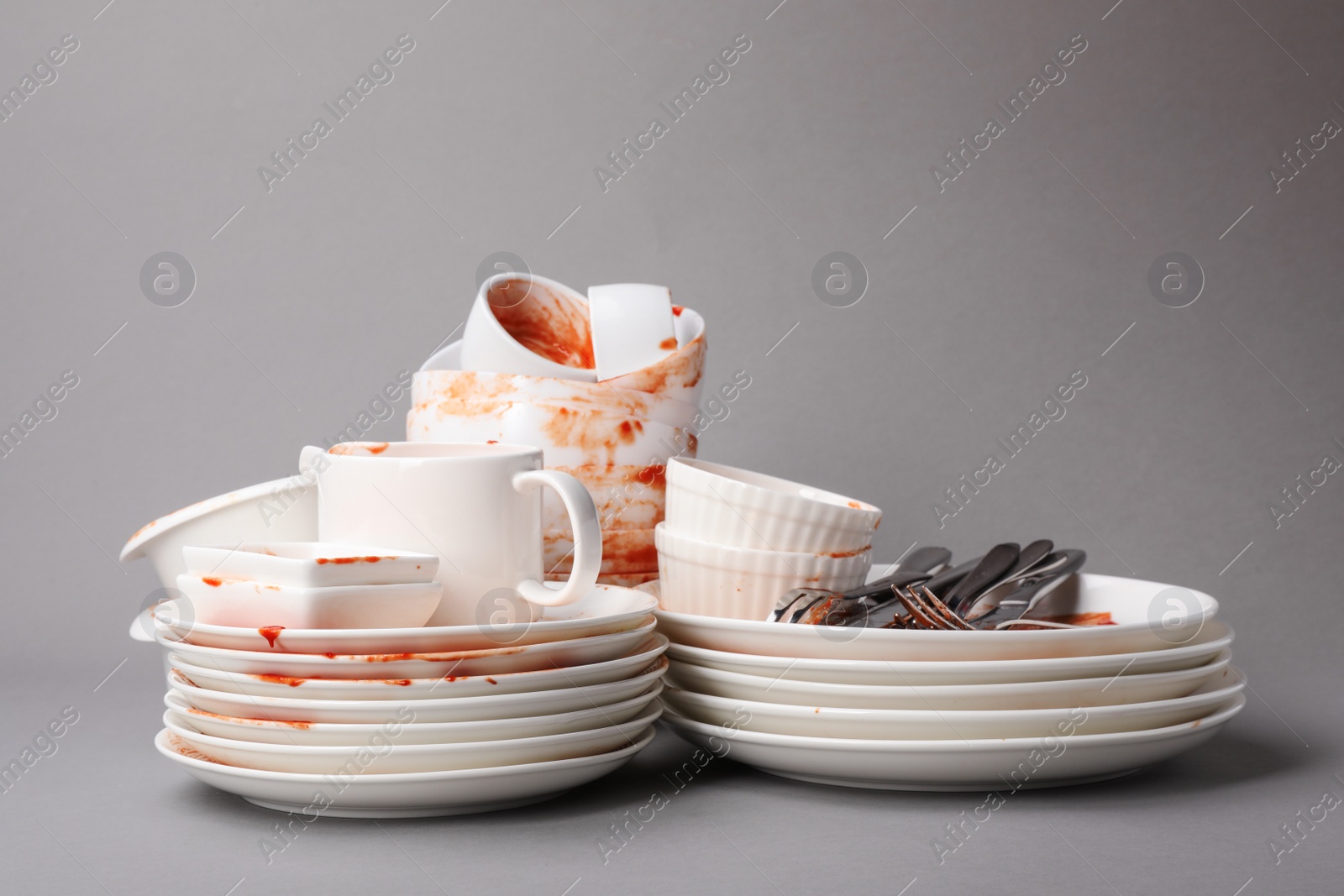 Photo of Set of dirty dishes on grey background