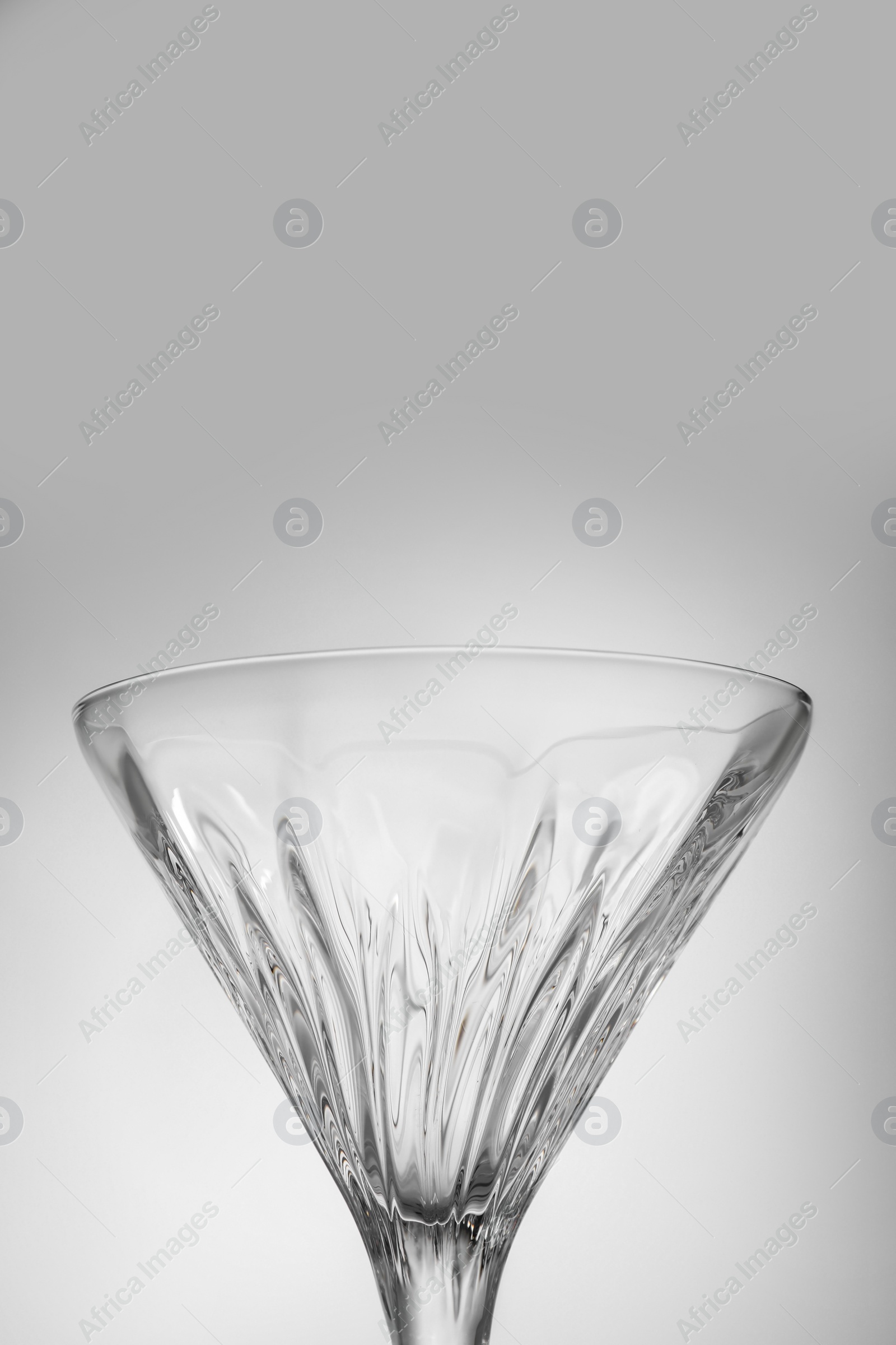 Photo of Elegant empty martini glass on grey background, closeup. Space for text