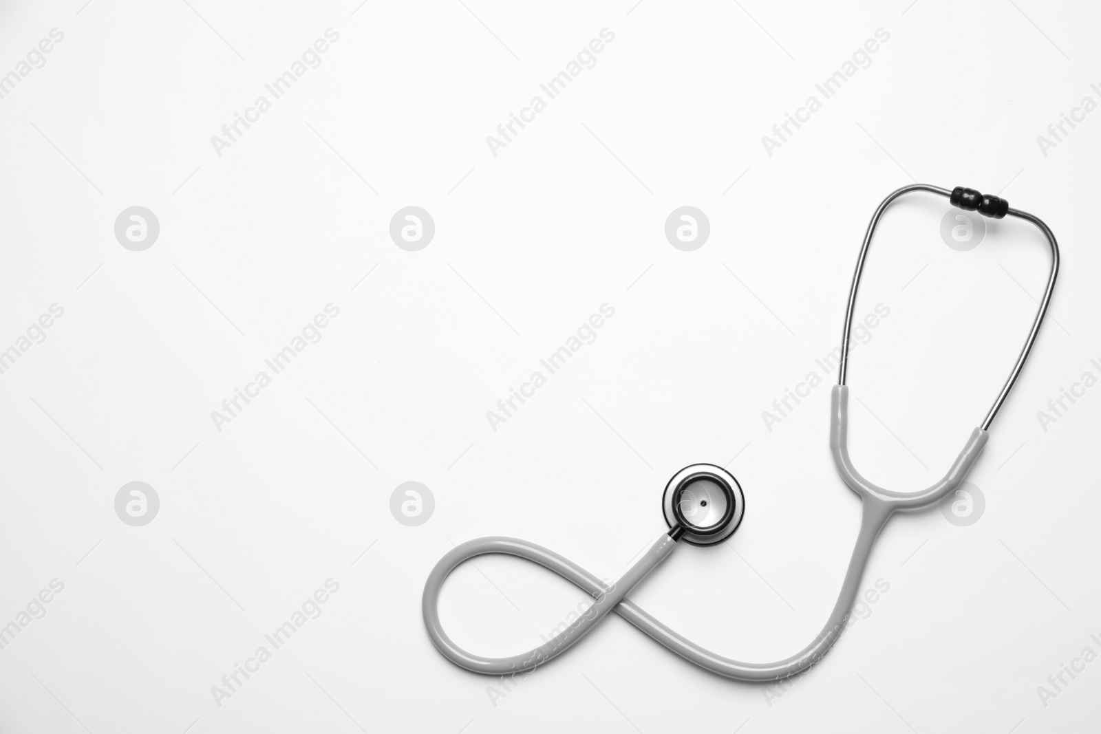 Photo of Stethoscope on white background, top view. Space for text