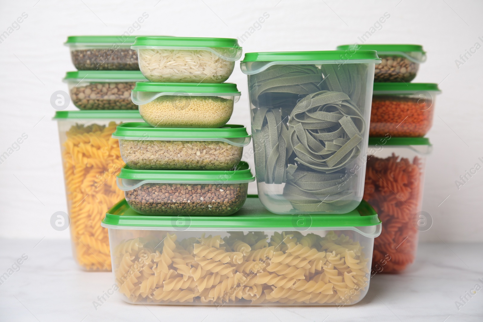 Photo of Plastic containers filled with food products on white table