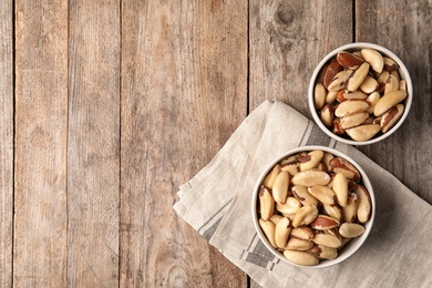 Photo of Flat lay composition with Brazil nuts and space for text on wooden background