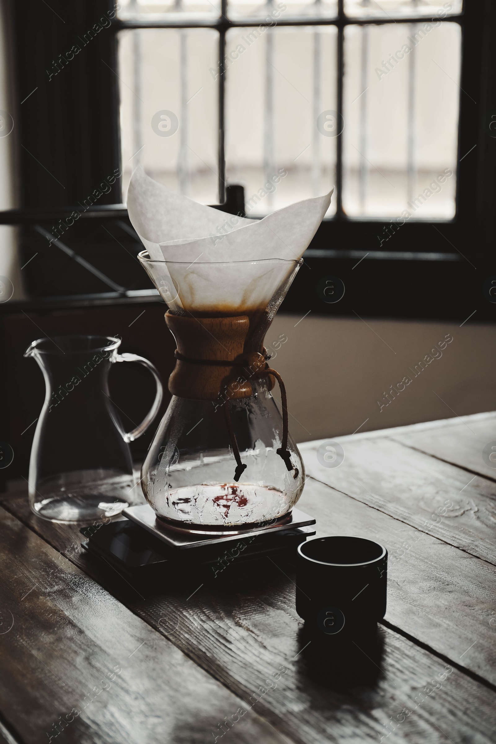 Photo of Dishware for coffee making on wooden table in cafe