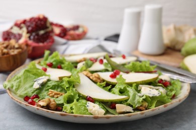 Delicious pear salad on grey textured table, closeup