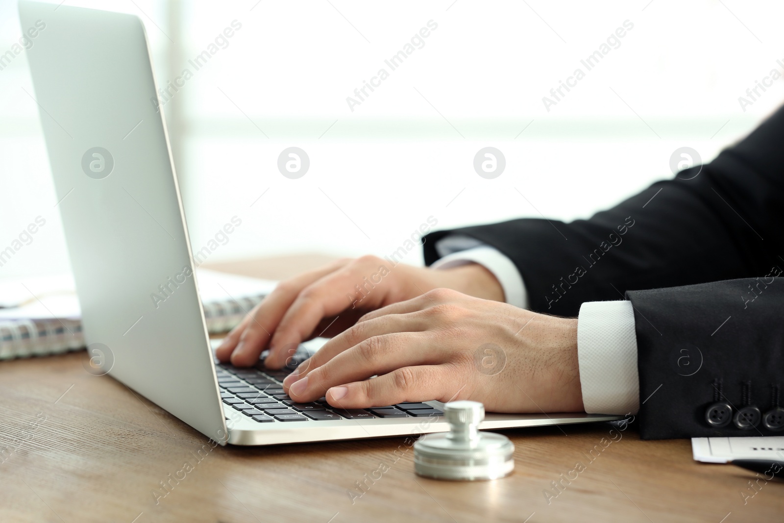 Photo of Male notary working with laptop at table, closeup