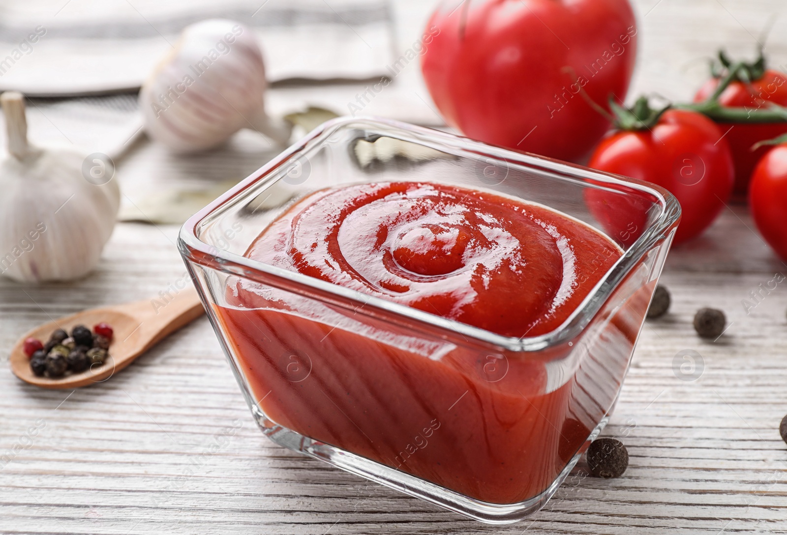 Photo of Delicious tomato sauce on white wooden table, closeup