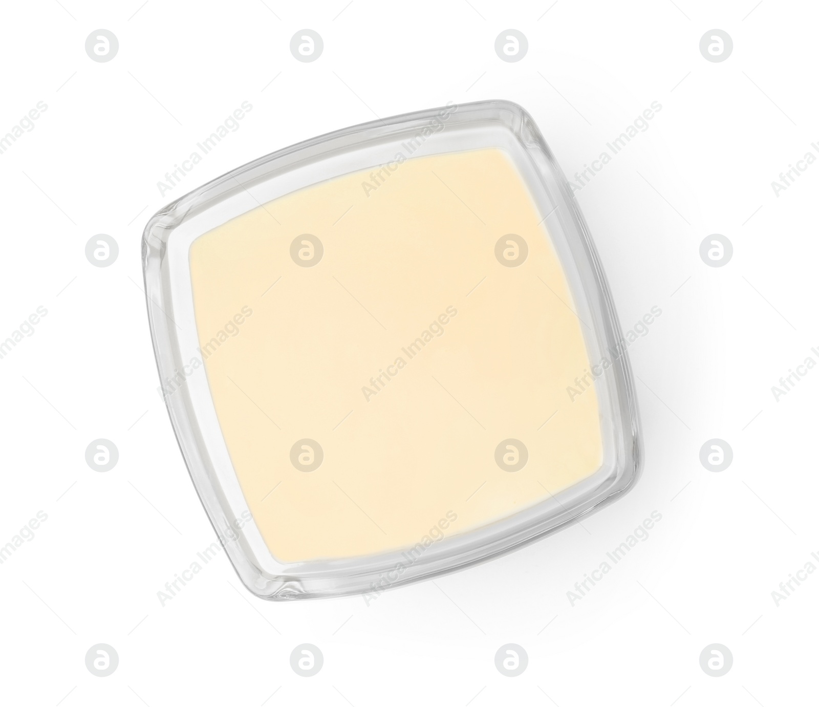 Photo of Glass bowl with condensed milk isolated on white, top view