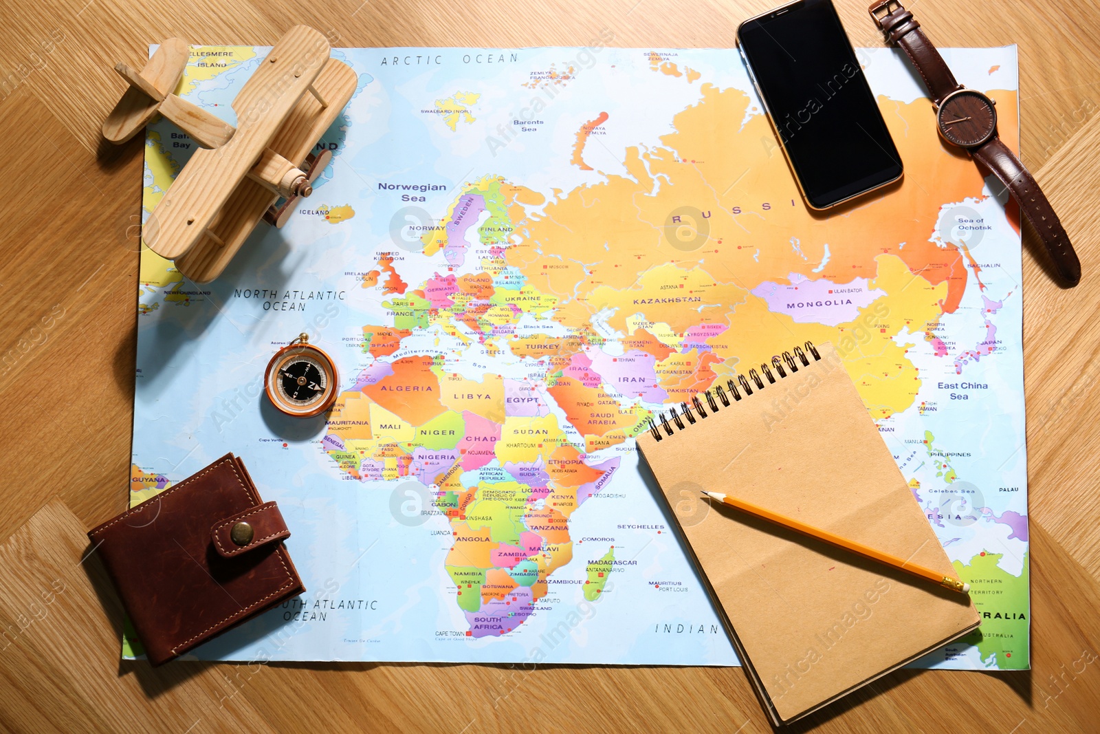 Photo of Flat lay composition with world map and different items on wooden background. Trip planning