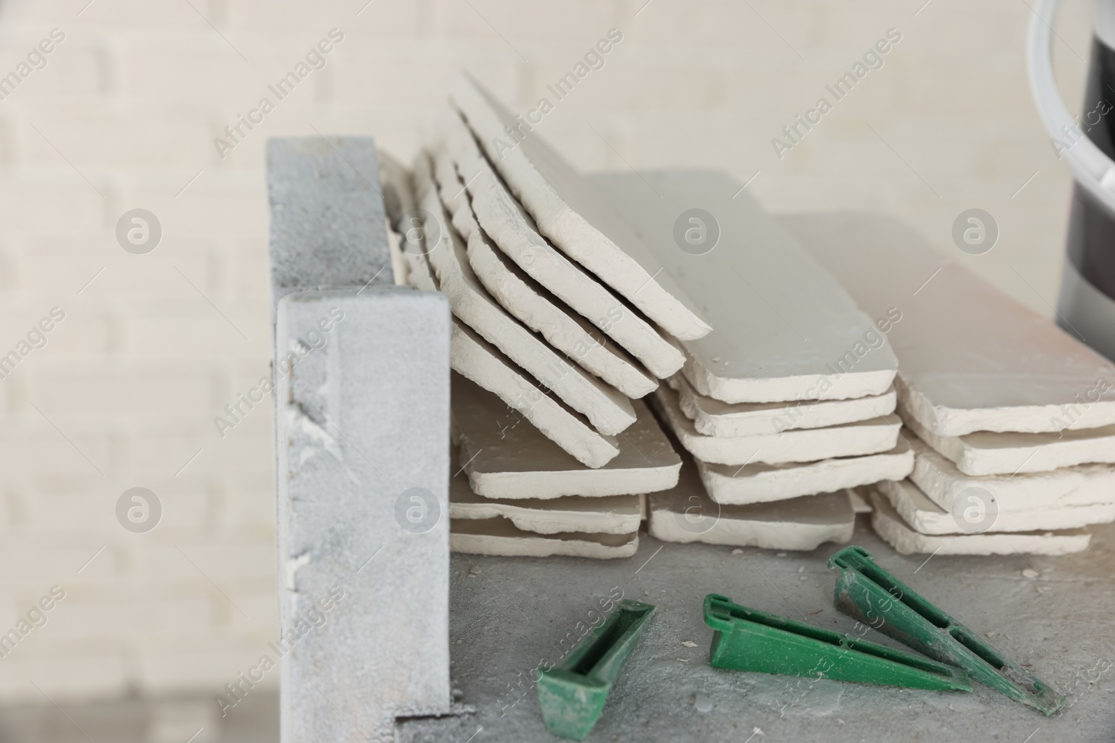 Photo of Many white decorative bricks and tile spacers in room